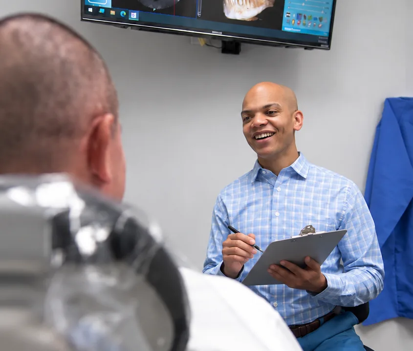 Dr. Davis reviewing a treatment plan with a patient during a consultation at The Teeth Doctors in Fayetteville, NC